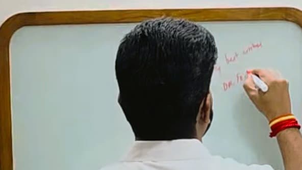 Dr. T. K. Prabhu signing the Ceramic Coated Magnetic Glass Board